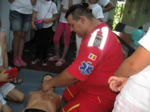 Membru al Ambulanței Samaritanus învățând copii să acorde primul ajutor